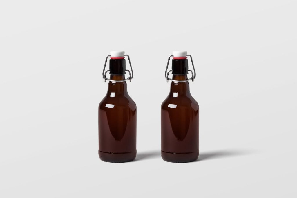 Two brown glass bottles with swing tops on a plain backdrop. Perfect for mockups and product displays.